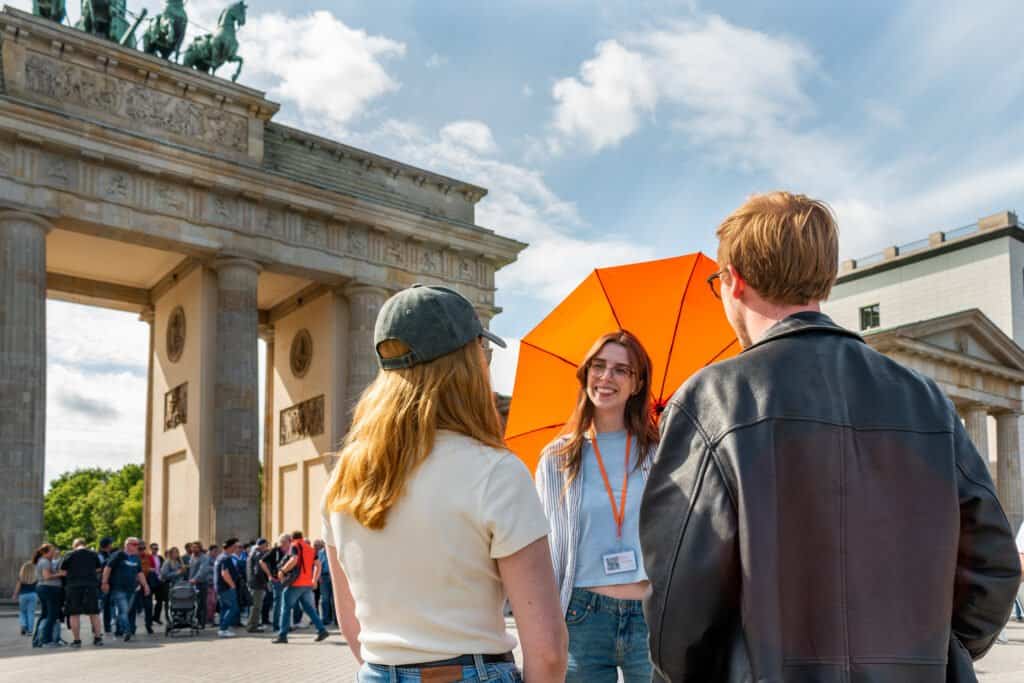 Local Expert Emily on a Highlights of Berlin Free Walking Tour with 2 guests in front of the Brandenburg Gate